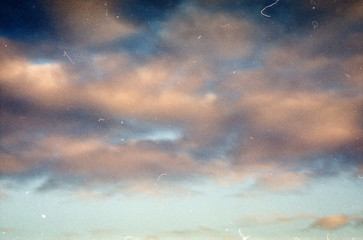 Grunge image of evening sky with clouds on grainy film texture