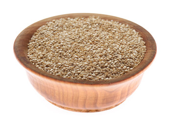 Raw organic superfood gluten free quinoa seeds in wooden bowl closeup isolated on white background