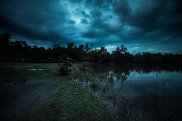 Wall Mural - moonlight shines behind a cloudy at night over tranquil lake