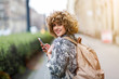© pikselstock - Young woman wearing backpack in city