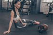 © mad_production - Full length shot of a gorgeous long haired sportswoman resting after exercising, sitting on gym floor, looking away thoughtfully. Beautiful fitness woman relaxing after workout, copy space. Health con