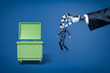 © gearstd - Big robotic hand in suit holding little businessman in order to throw him right into trash can.