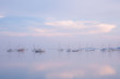 view of boats reflected over the calm sea at blue hour