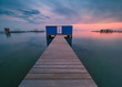 view of a blue hut on the pier in a sunset at blue hour over the calm sea