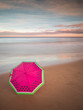 umbrella on the sand of the beach in a sunset in long exposure
