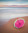 umbrella on the sand of the beach in a sunset in long exposure