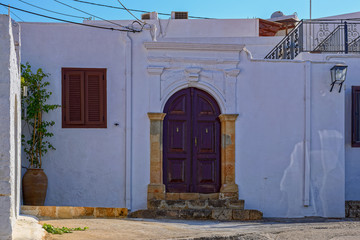 Greek architecture with traditional doors and decorative pavement in Lindos town, Rhodes island, Greece.