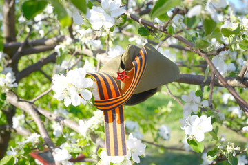 Wall Mural - St. George ribbon, soldier's cap, paper crane on the background of a blooming Apple tree / St. George ribbon-a symbol of the great Victory / victory Day.