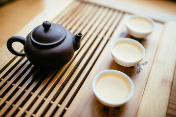 Teapot and cups with chinese tea near window on the table for the tea ceremony