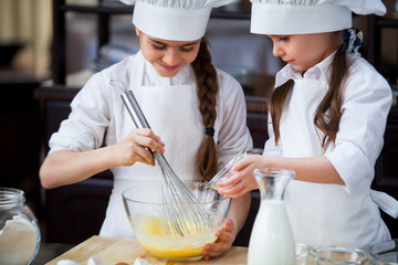 two girls make flour dough.