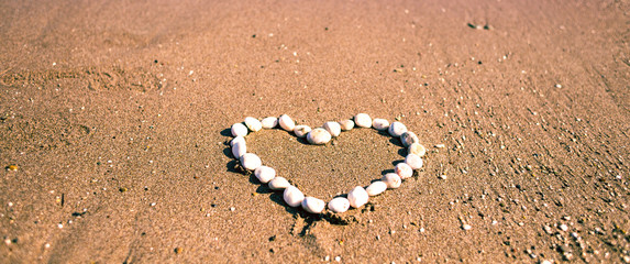 Heart of pebbles on the sand.