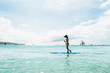 © matilda553 - Woman is enjoying a view in standup paddleboarding over the ocean