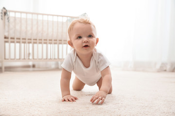 cute little baby crawling on carpet indoors