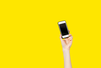 Peson hand holding mobile phone on yellow background