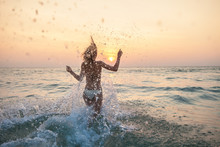 Woman Running Into The Sea With Lots Of Splashes