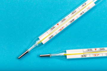 mercury  thermometers on blue background close up view