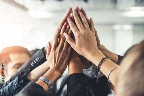 Fotografía Many happy business people raise hands together with joy and success