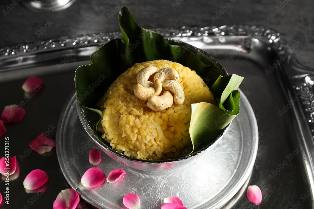 Bowl with traditional Indian food pongal on table