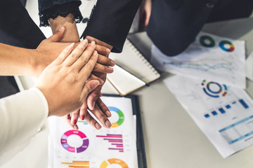 Wall Mural - Many happy business people stacking hands together with joy and success. Company employee celebrate after finishing successful work project. Corporate partnership and achievement concept.