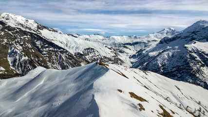 Sticker - Panoramic drone view of a mountain top and surroundings covered by snow in the Alps