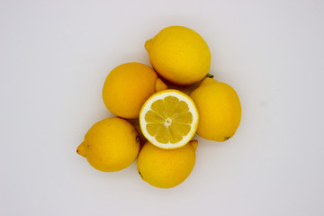 Wall Mural - Many lemons and a half of a lemon isolated image on a white background