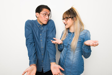 Wall Mural - Young couple with glasses making unimportant gesture while lifting the shoulders