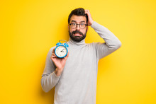 Man With Beard And Turtleneck Restless Because It Has Become Late And Holding Vintage Alarm Clock