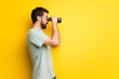 © luismolinero - Man with beard and green shirt and looking in the distance with binoculars