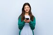 © luismolinero - Teenager girl over blue wall sending a message with the mobile