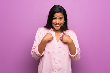 Wall Mural - Young Colombian girl over purple wall with surprise facial expression