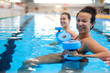 © Nejron Photo - Multiracial couple attending water aerobics class in a swimming pool