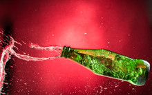 Flying Falling And Crashing Green Bottle On A Red Gradient Background, Shards And Splashes