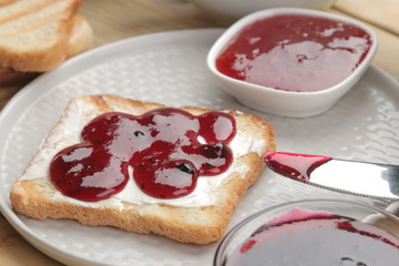 toasts with jam. fried crispy toast with red jam on a natural wooden table. breakfast.