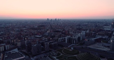 Canvas Print - Aerial view of Milan skyline at dawn. Flying over building and boulevard.