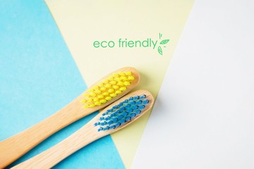 Yellow and blue bamboo toothbrushes. Eco-friendly concept. Minimal, geometric background. Top view, copy space