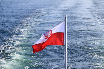 Polish flag waving on the mast of a ship at sea