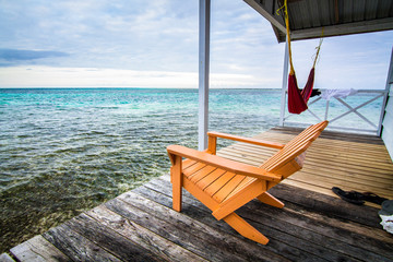 Poster - An armchair sits on a deck overlooking the Caribbean Sea. Photographed on Tobacco Caye, Belize.