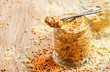 Mustard with grains, ready hot sauce, old wooden kitchen table background, selective focus