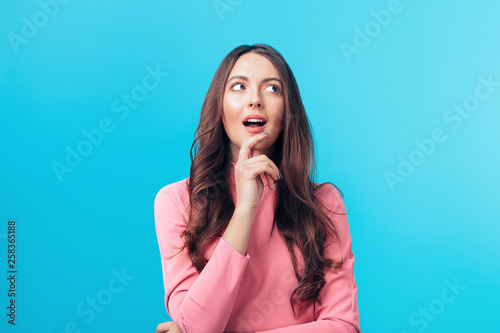 Fotografía Portrait of thoughtful happy woman looking sideways isolated on blue background