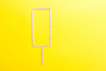 Wooden ice cream sticks in form on white background isolated, flat lay top