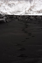 Footprints over Icelandic black sand beach