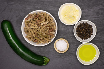 Wall Mural - Ingredients. recipe step by step fusilli pasta with zucchini flatlay on grey stone