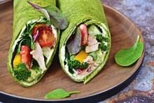 Two Fresh Chicken And Salad Spinach Tortilla Wraps On Blue Vintage Background