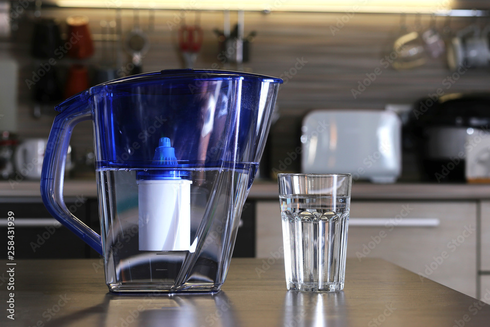 Glass of clean water and filter for cleaning drinking water on the ...