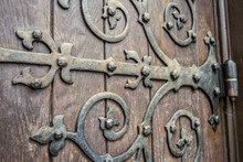 Close Up Of Big Ornate Cast Iron Door Hinge On Wood Plank Door