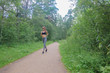 Girl in sportswear on a run in the forest. Woman jogging in nature.