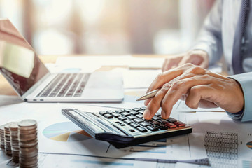 Fototapete - businessman working on desk with using calculator for calculate finance and accounting in office