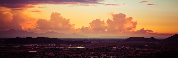 Wall Mural - A panorama of a dramatic sunset over the desert with buildings in the foreground