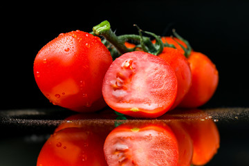 cut fresh tomato on a black background