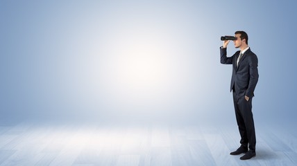 Wall Mural - businessman looking forward with binoculars in an empty space